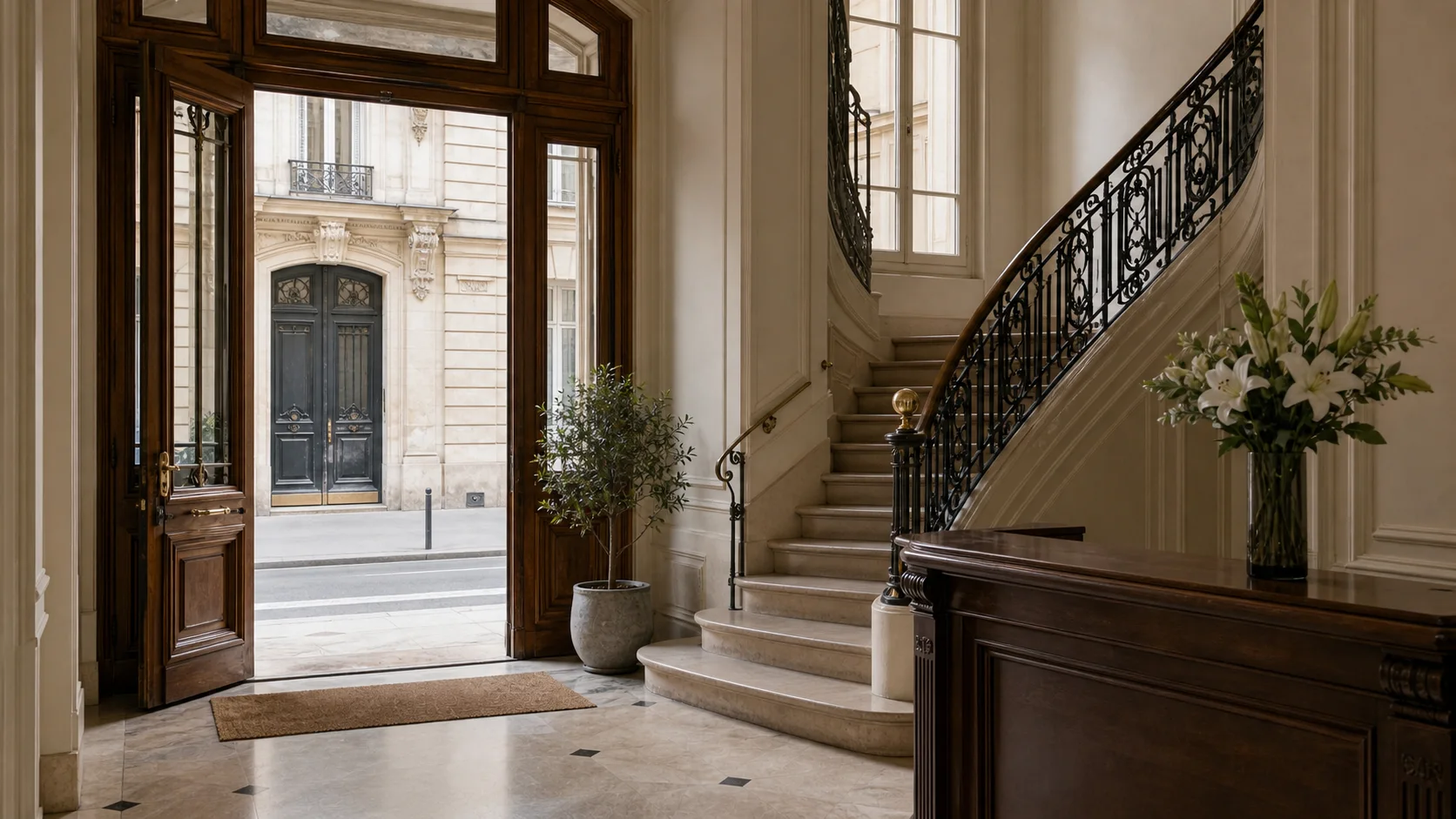Entree elegante d'un immeuble haussmannien parisien avec escalier et ferronneries